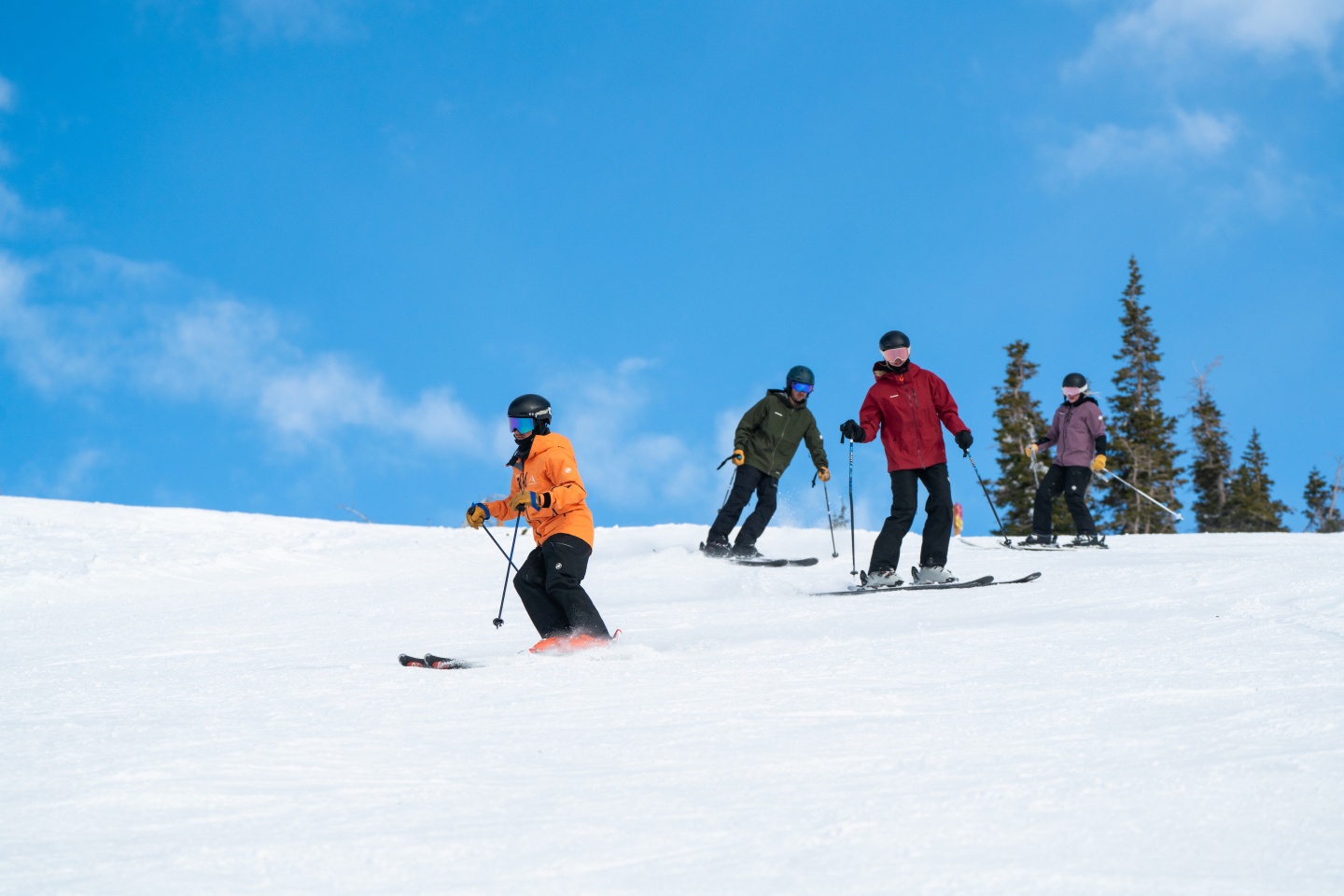 Instructor and three skiers on a slope