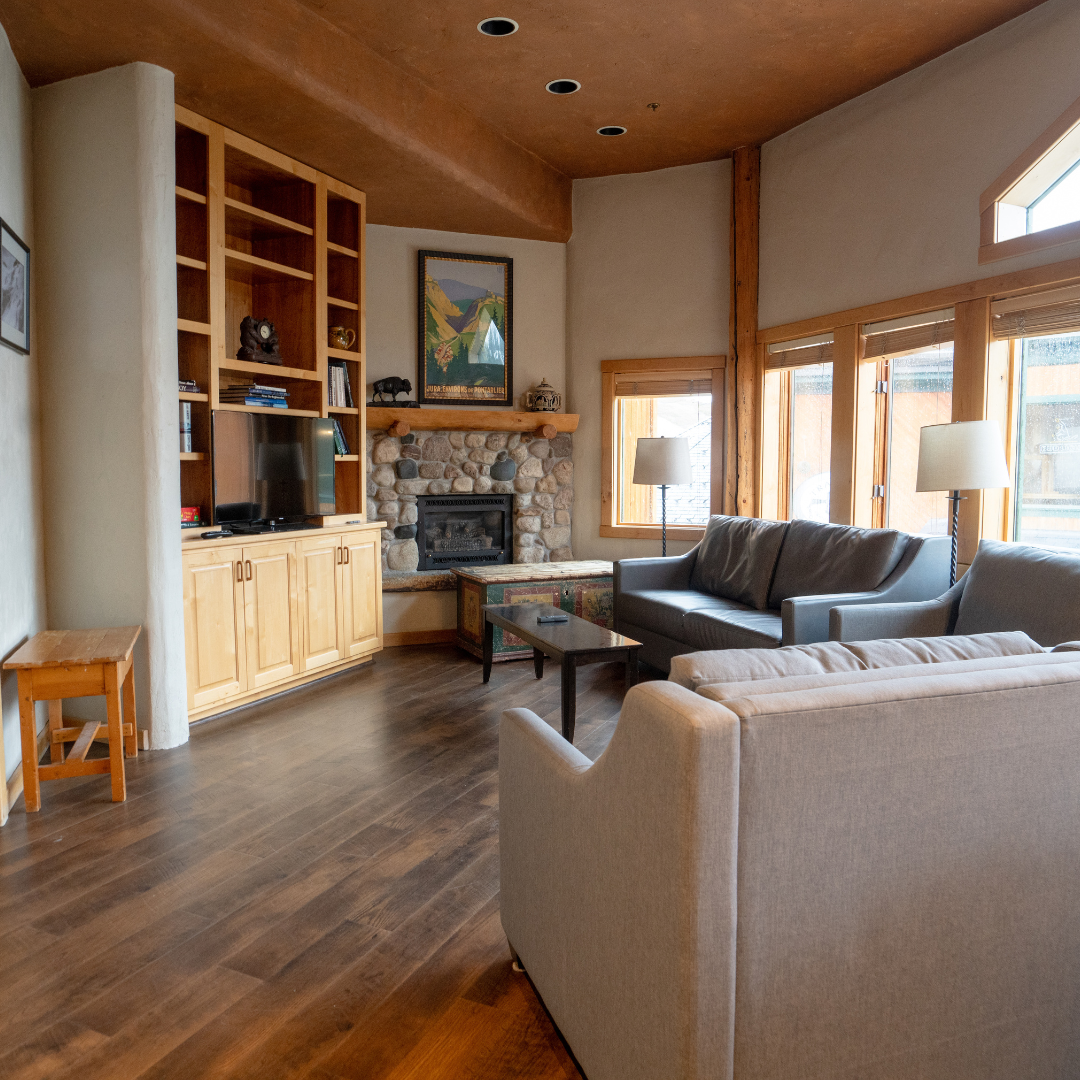 Cozy living room with sofas, fireplace, and large windows.
